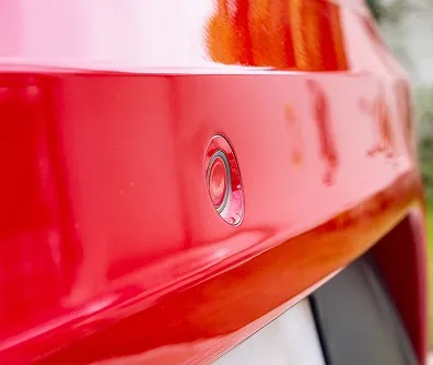 Sensor de estacionamento instalado no para-choque de um carro vermelho