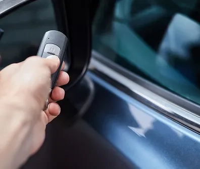 Mão acionando o controle do alarme do carro