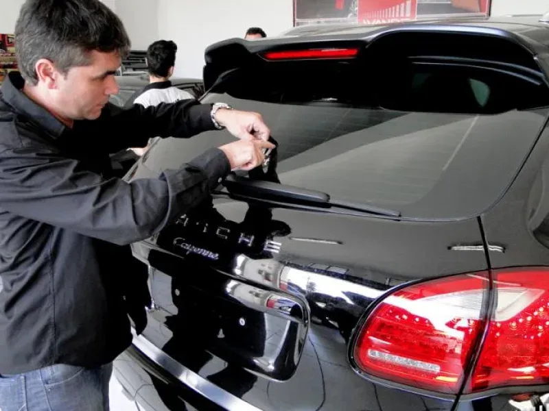 Técnico da Wande instalando acessório na traseira de um Porsche Cayenne