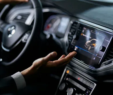 Motorista interagindo com a tela multimídia do carro